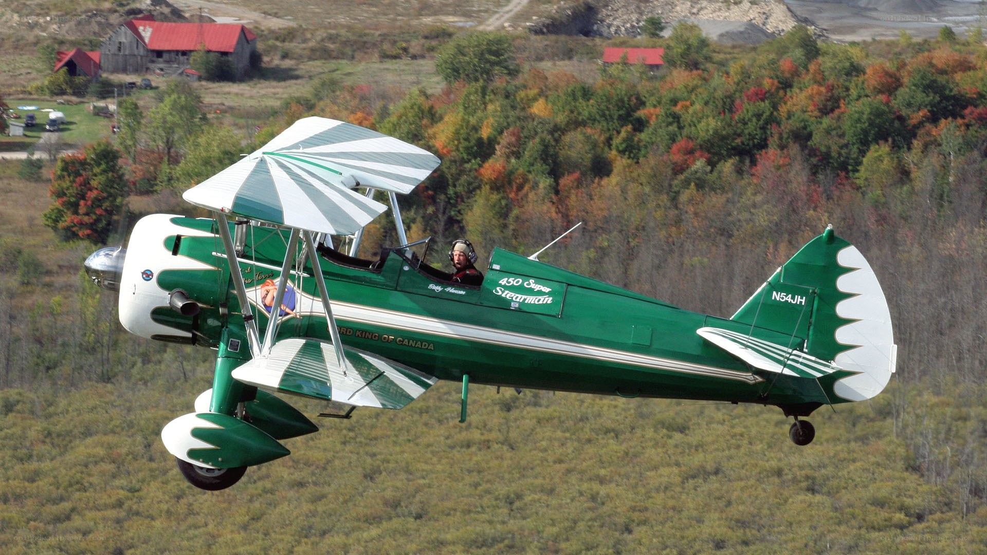 Green biplane in flight