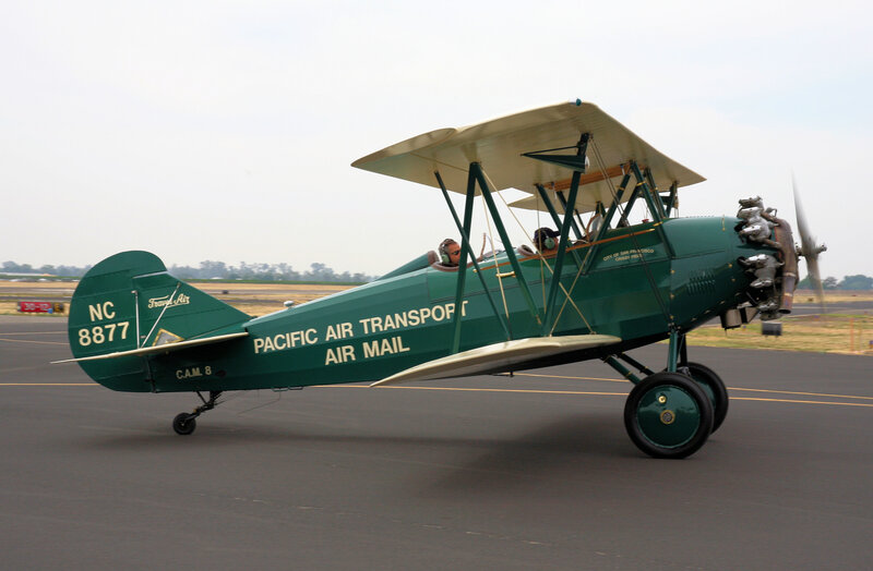 Green biplane on tarmac