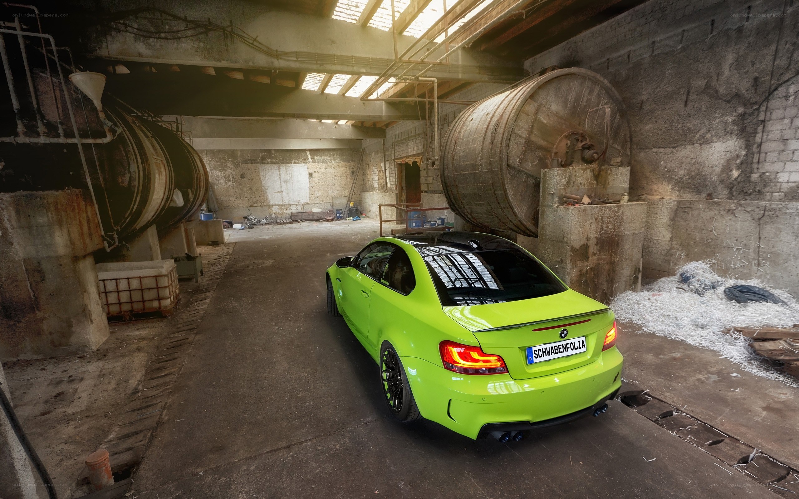 Green BMW in industrial warehouse