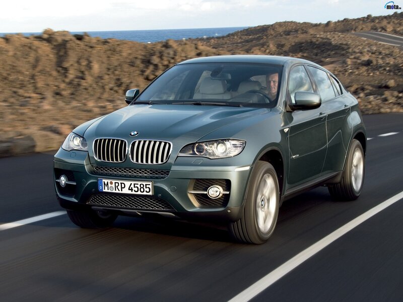 green bmw x6 driving on road