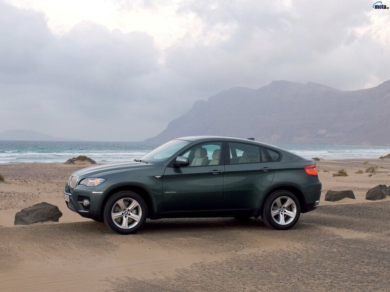 Green BMW X6 on a beach