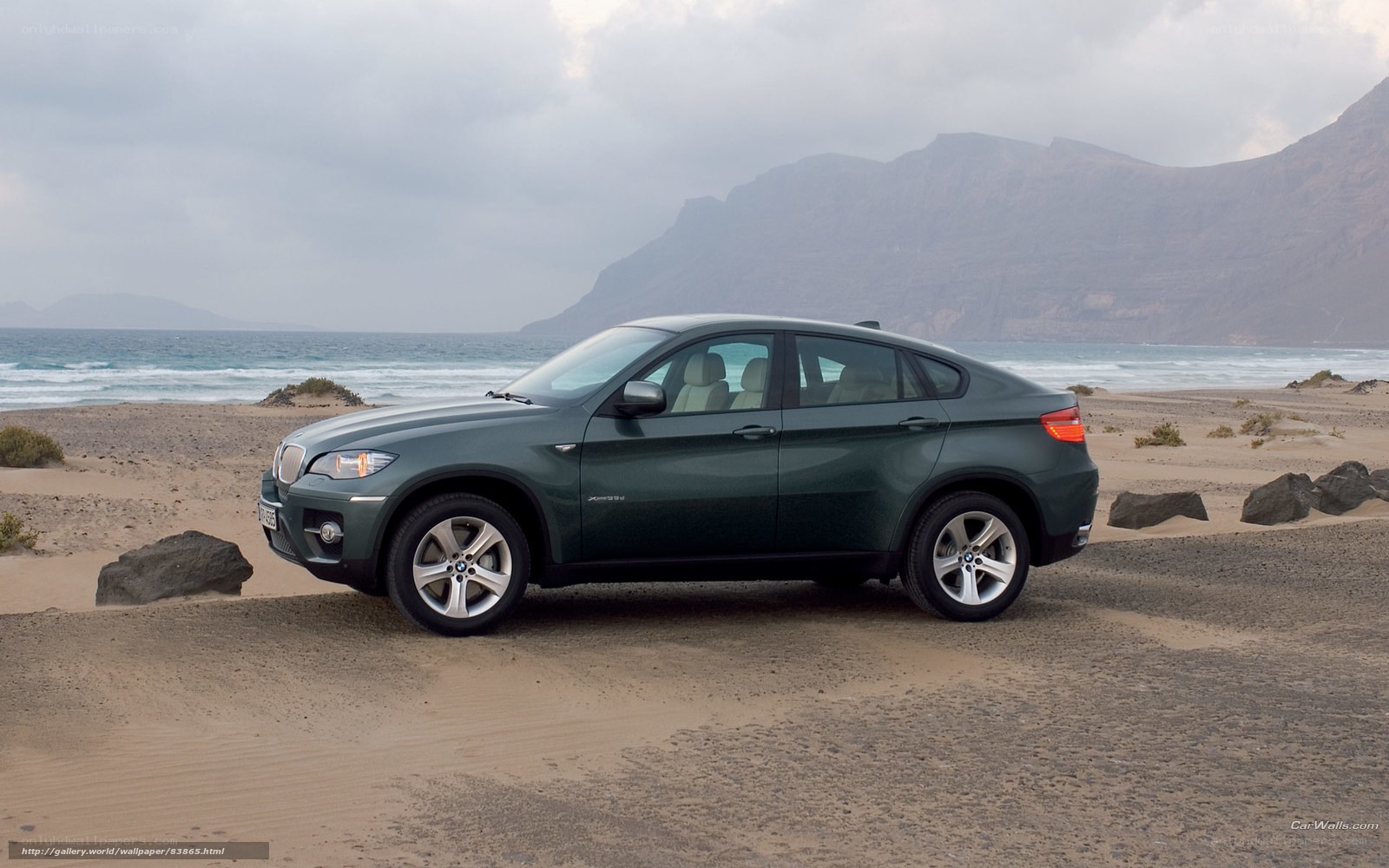 Green BMW X6 on a beach
