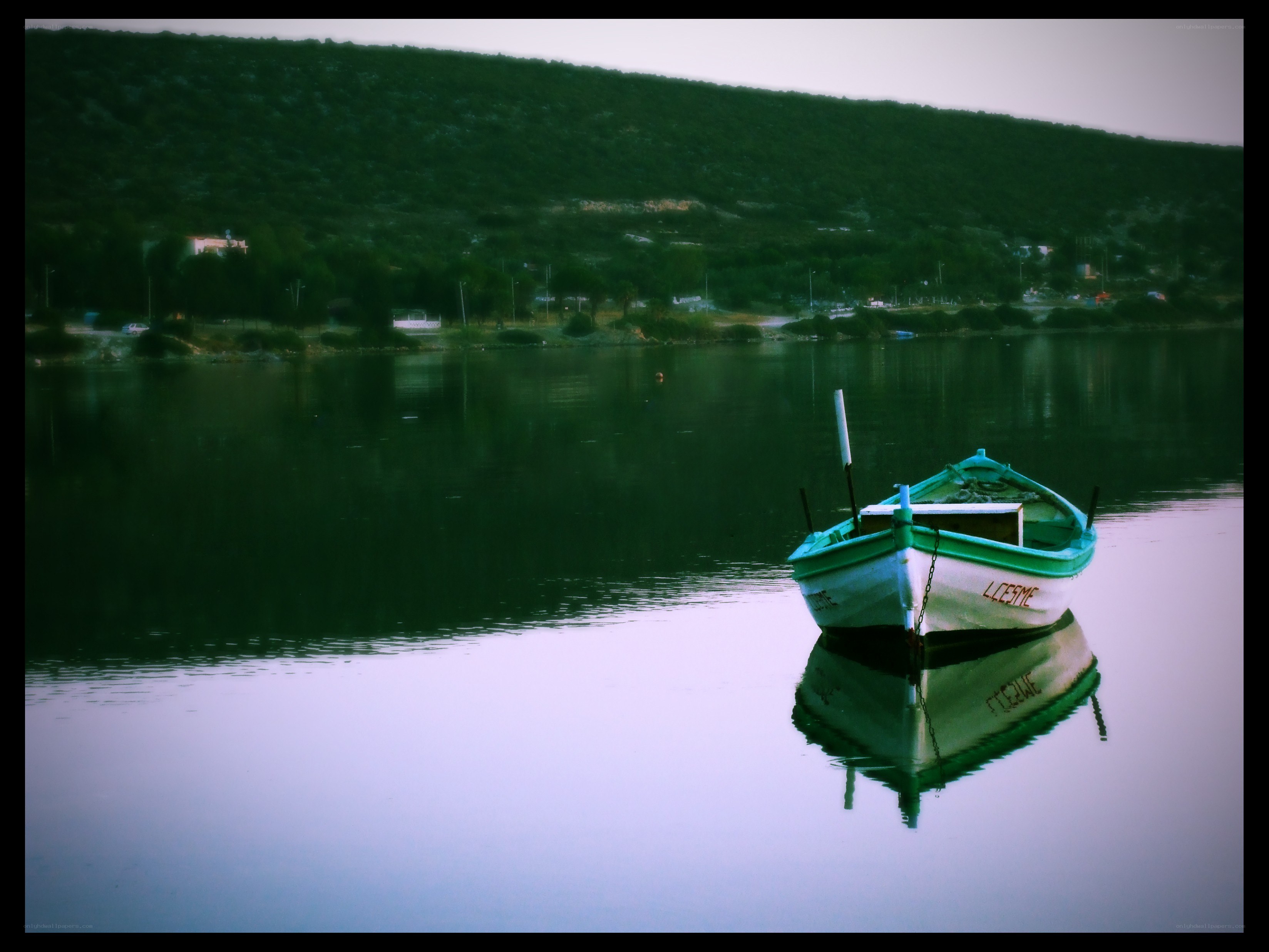 Green boat on calm water