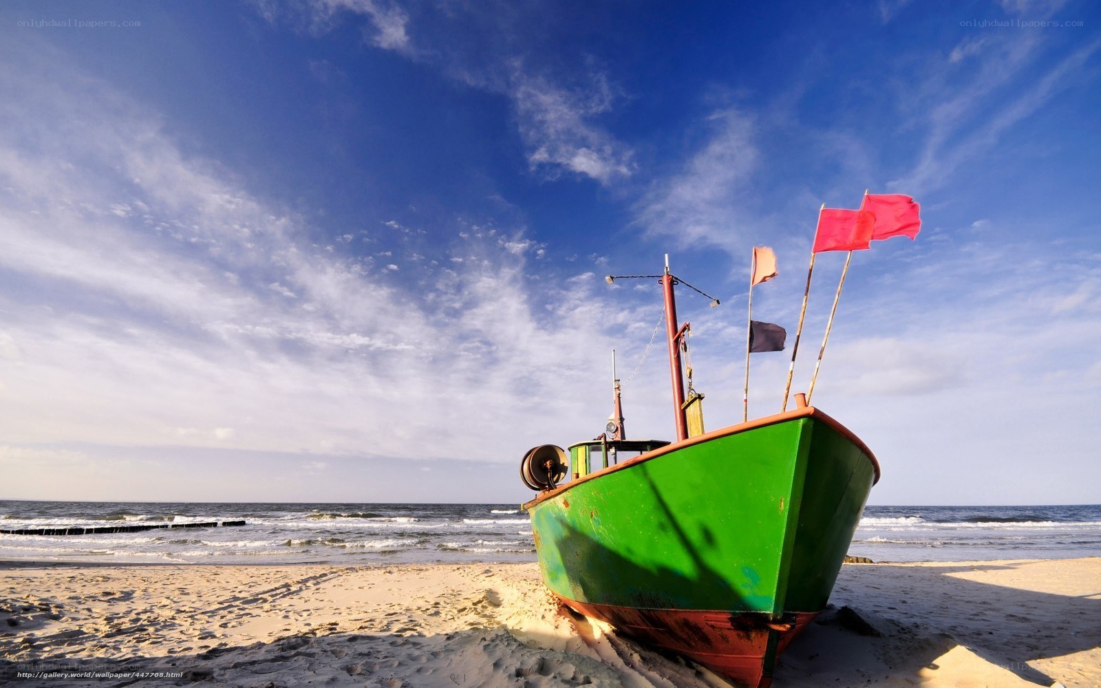 Green boat on sandy beach