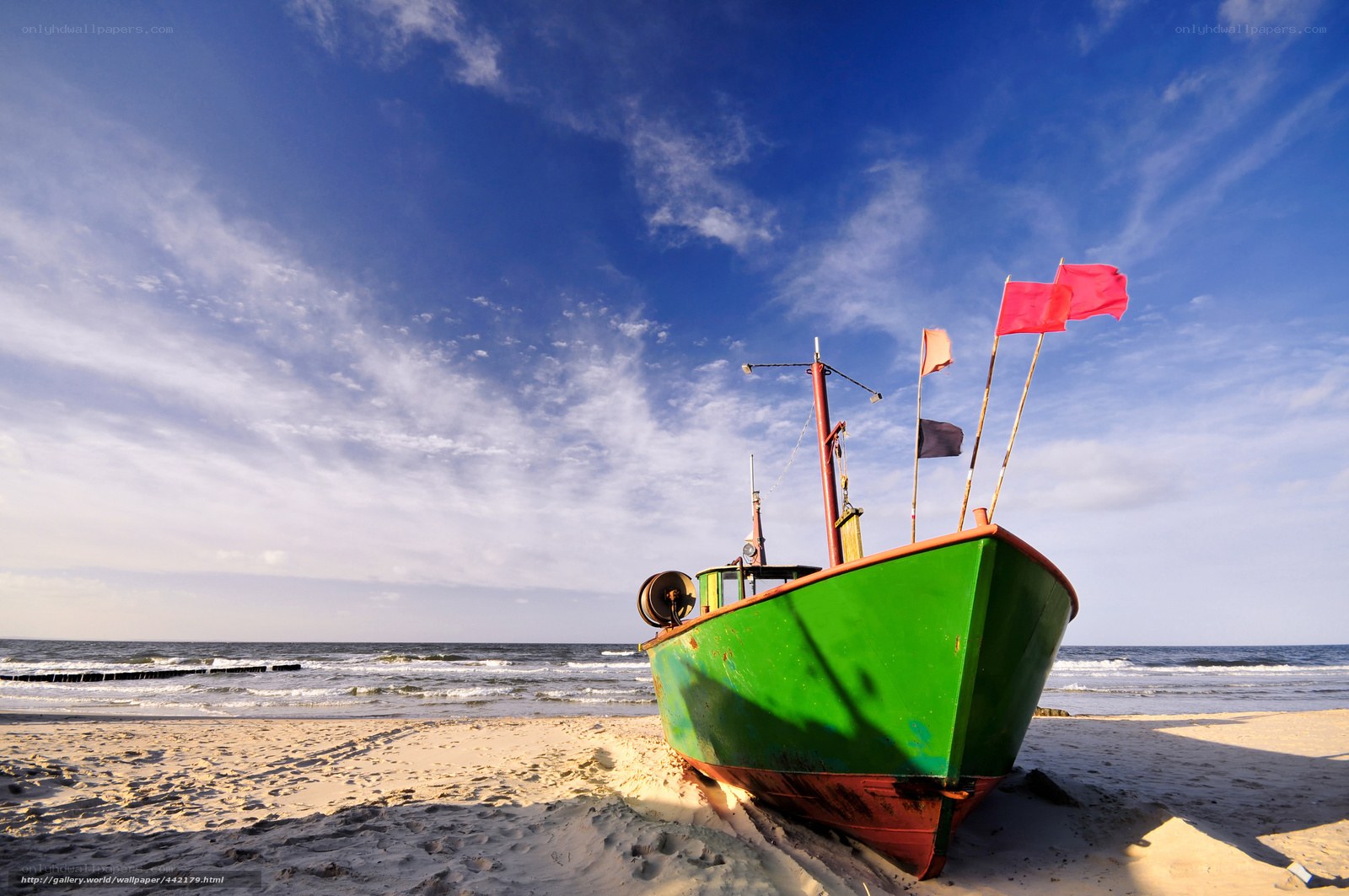 Green boat on sandy beach