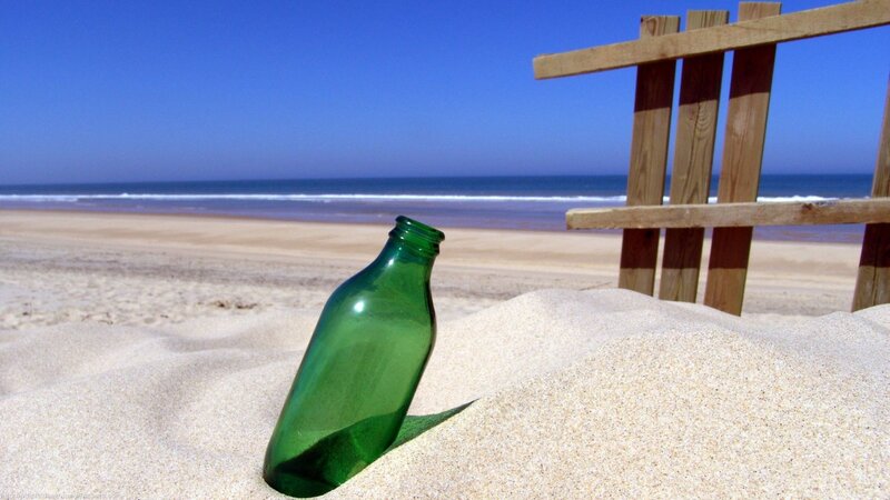 green bottle on sandy beach