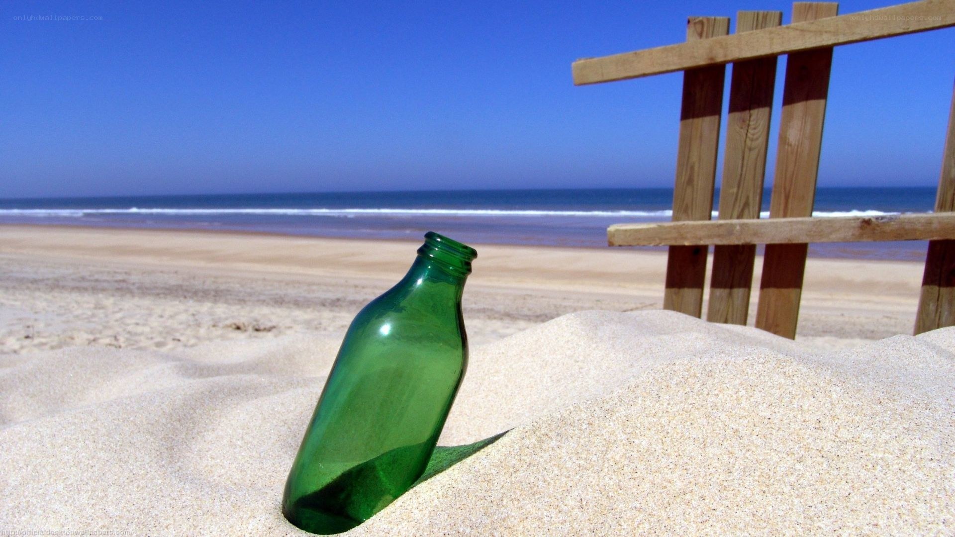 green bottle on sandy beach