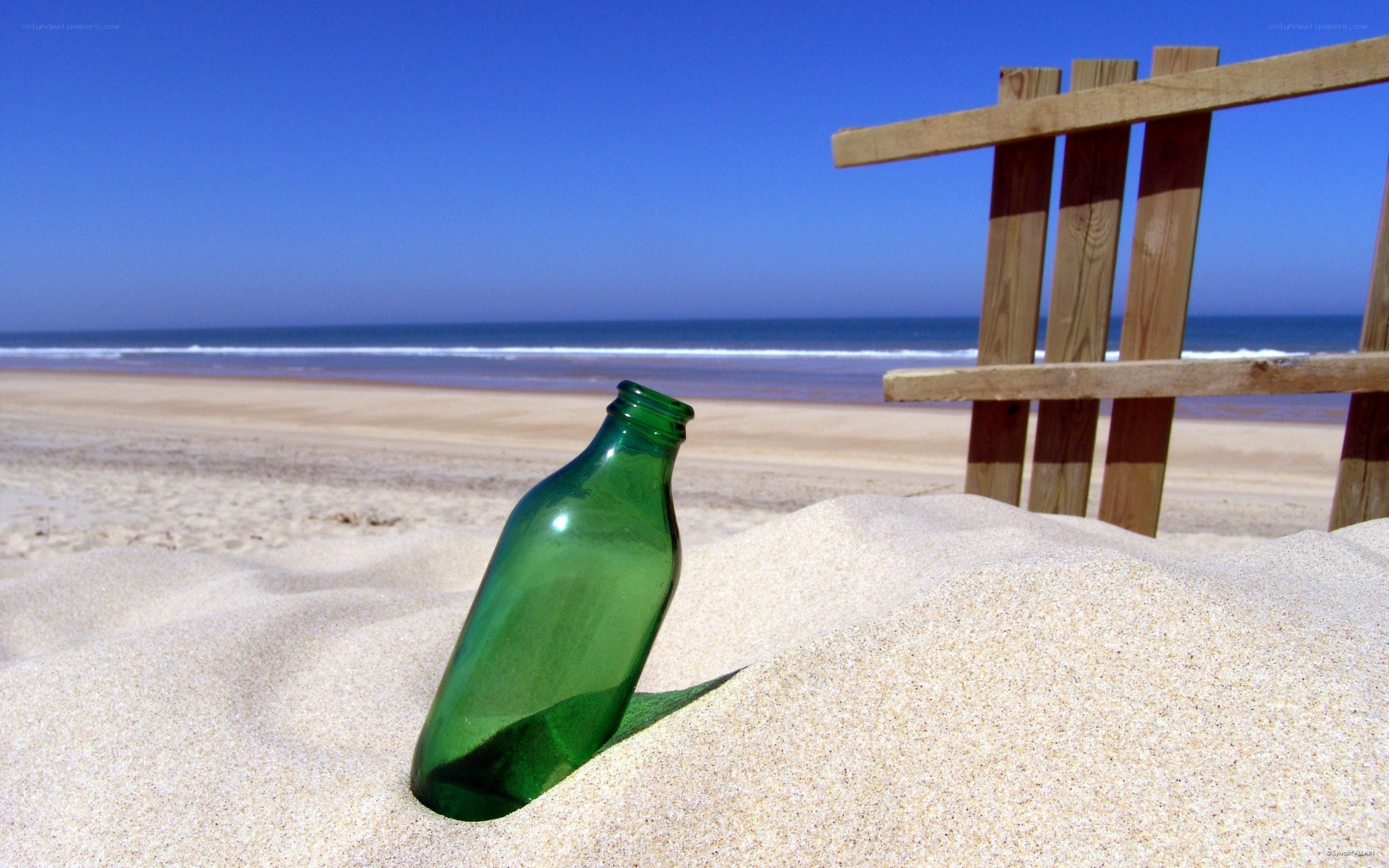 green bottle on sandy beach