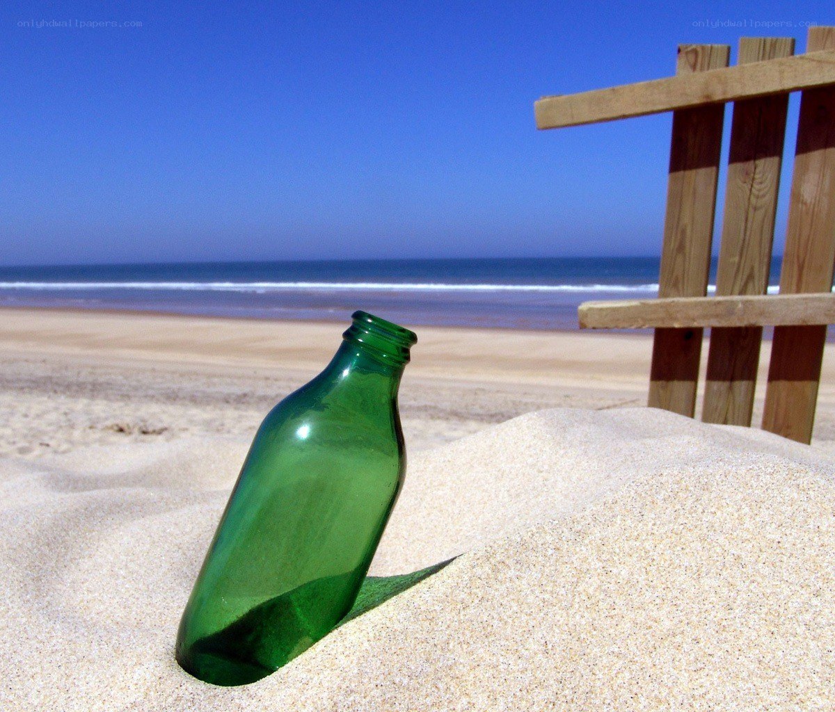 green bottle on sandy beach