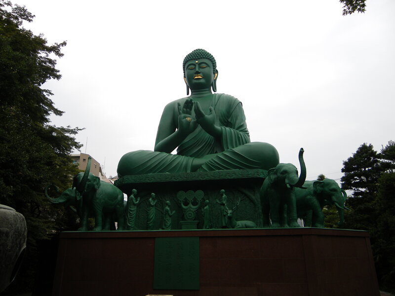 Green Buddha statue with elephants