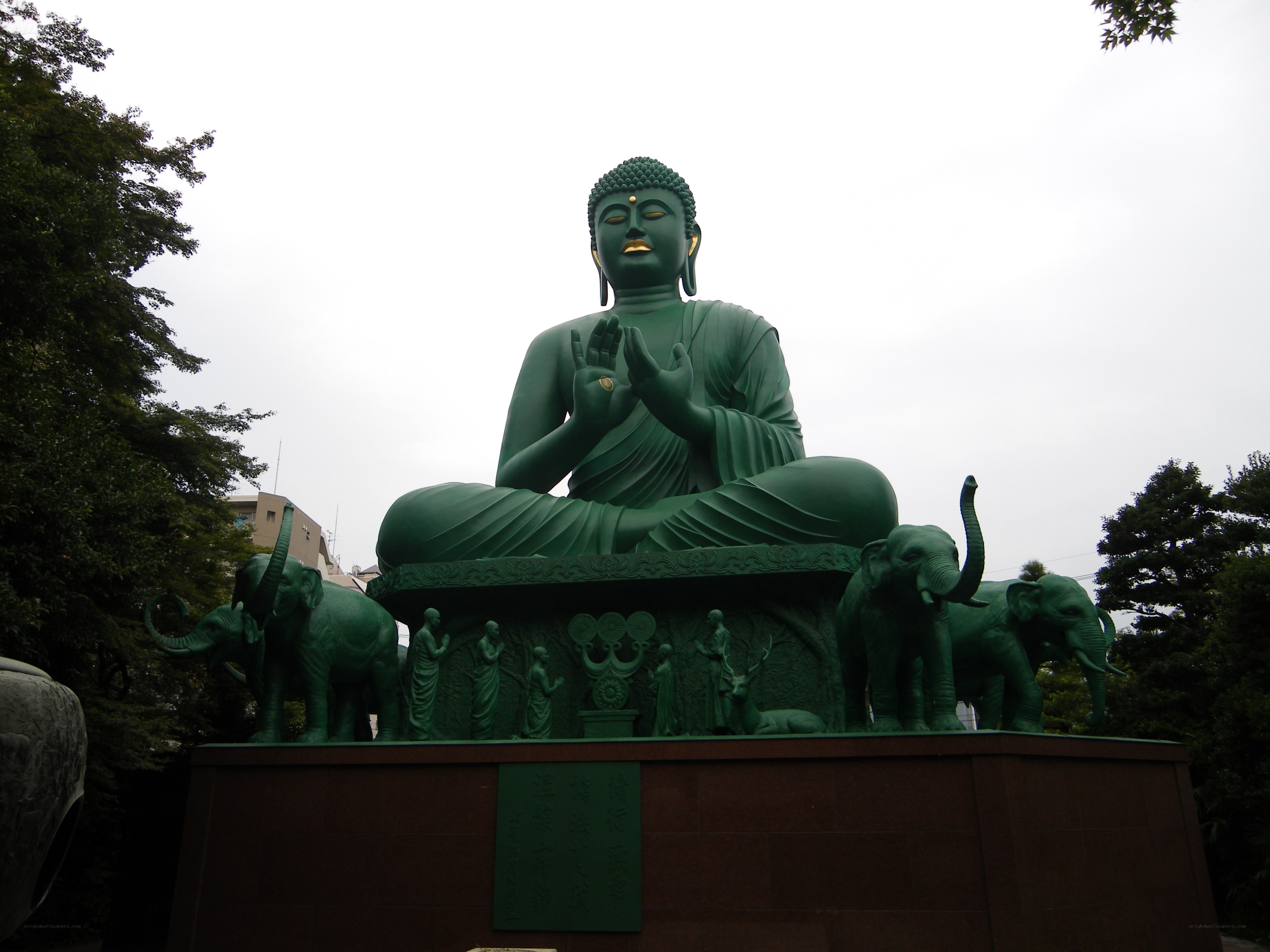Green Buddha statue with elephants