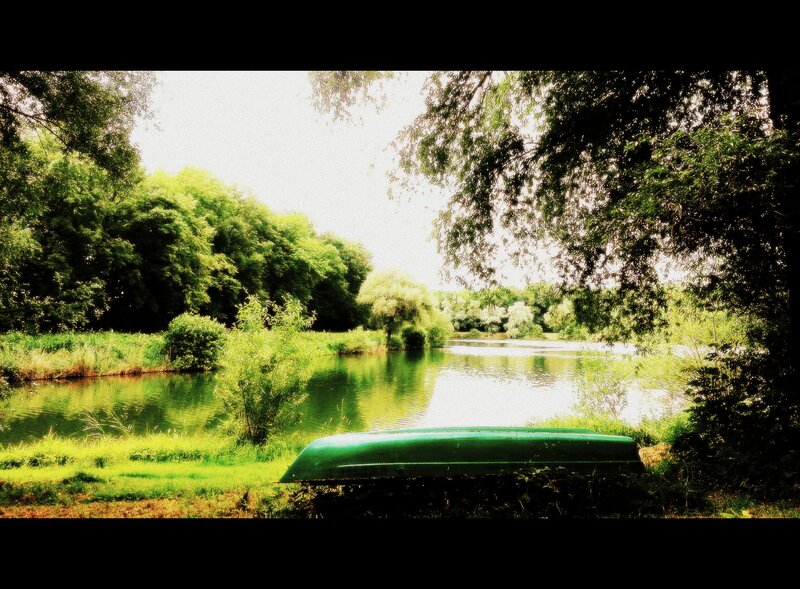 Green Canoe on Riverbank