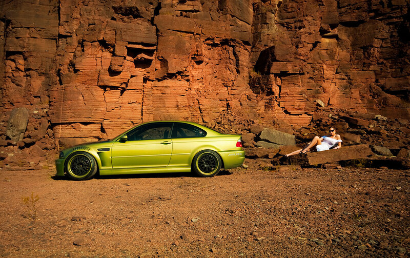 Green car and woman by cliff