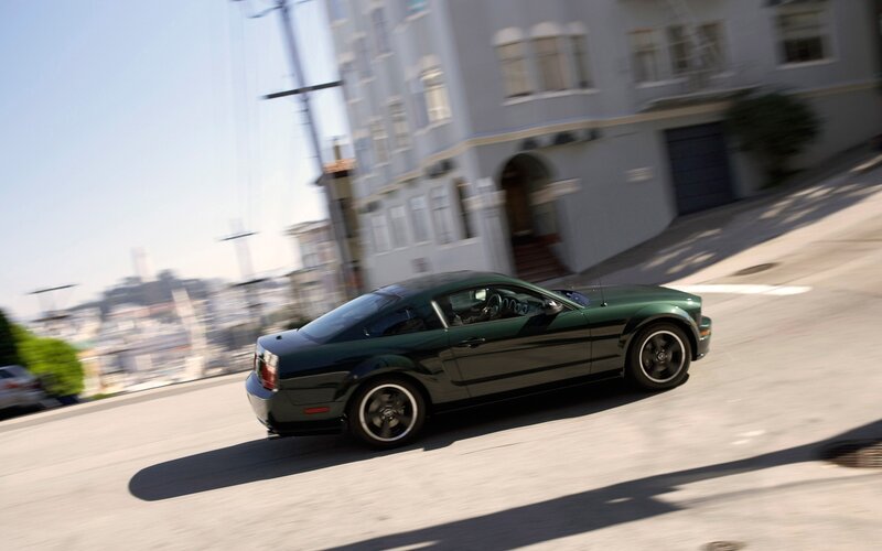green car driving on city street