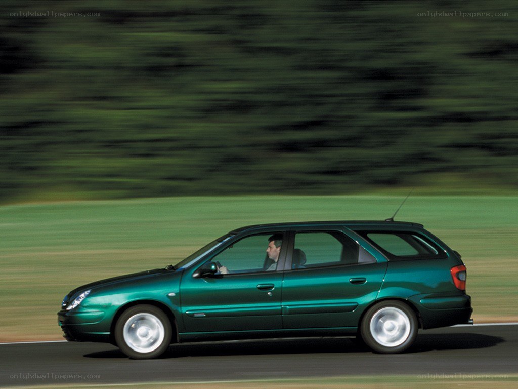green car driving on road