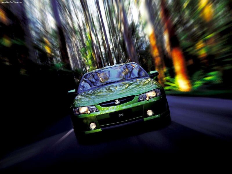 green car driving through forest