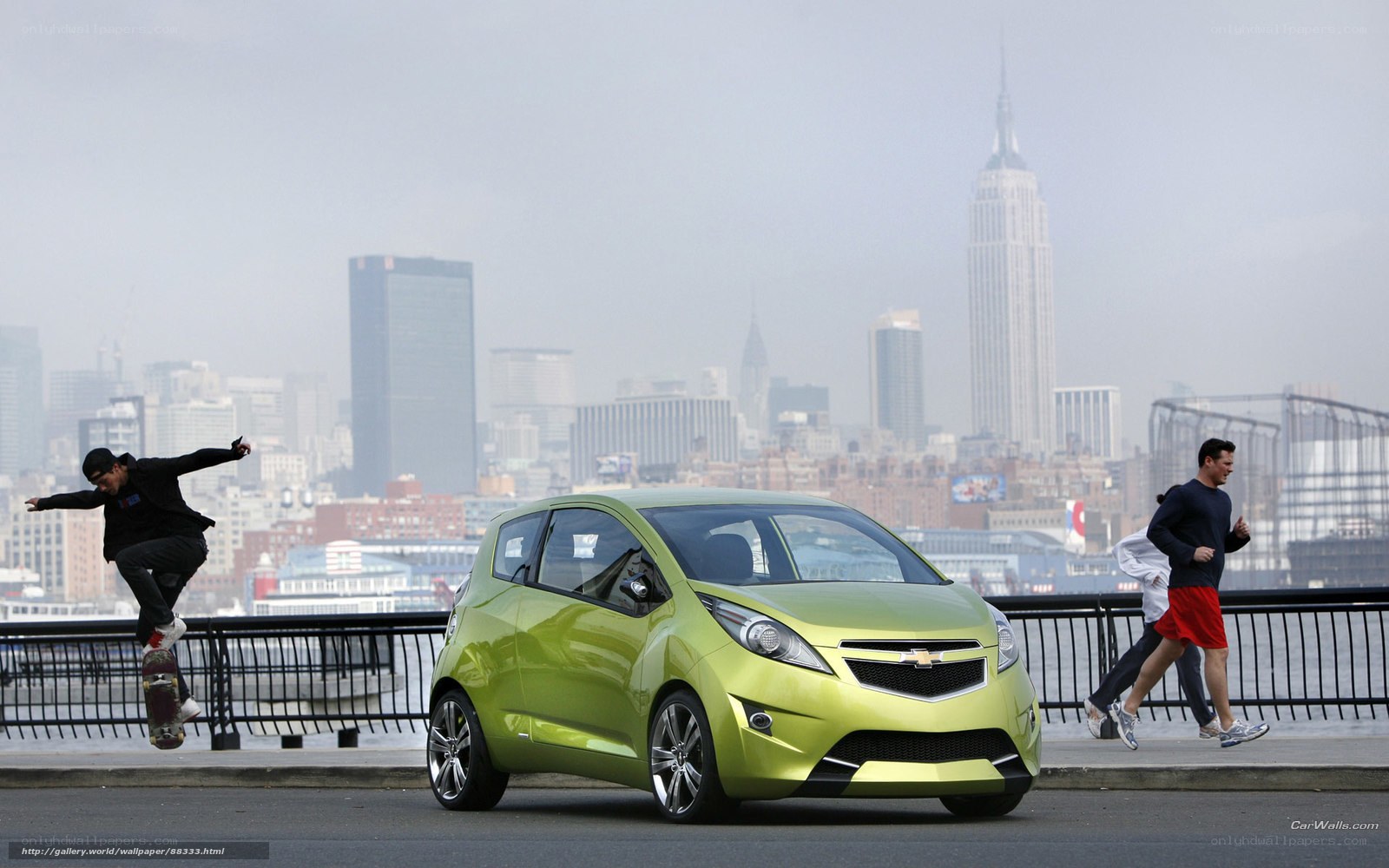 Green car in city with skateboarder