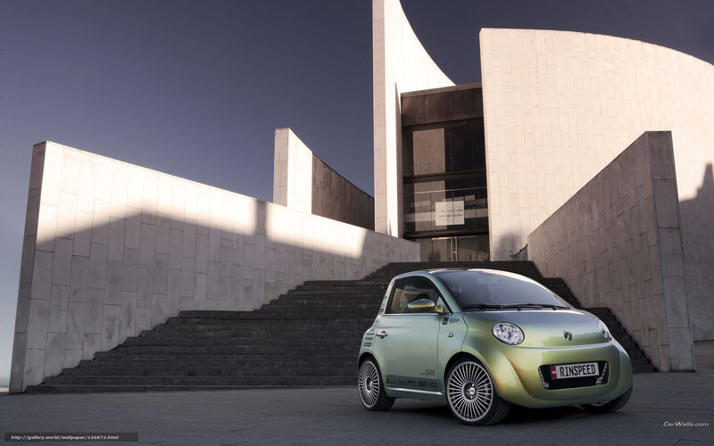 Green car in front of modern building