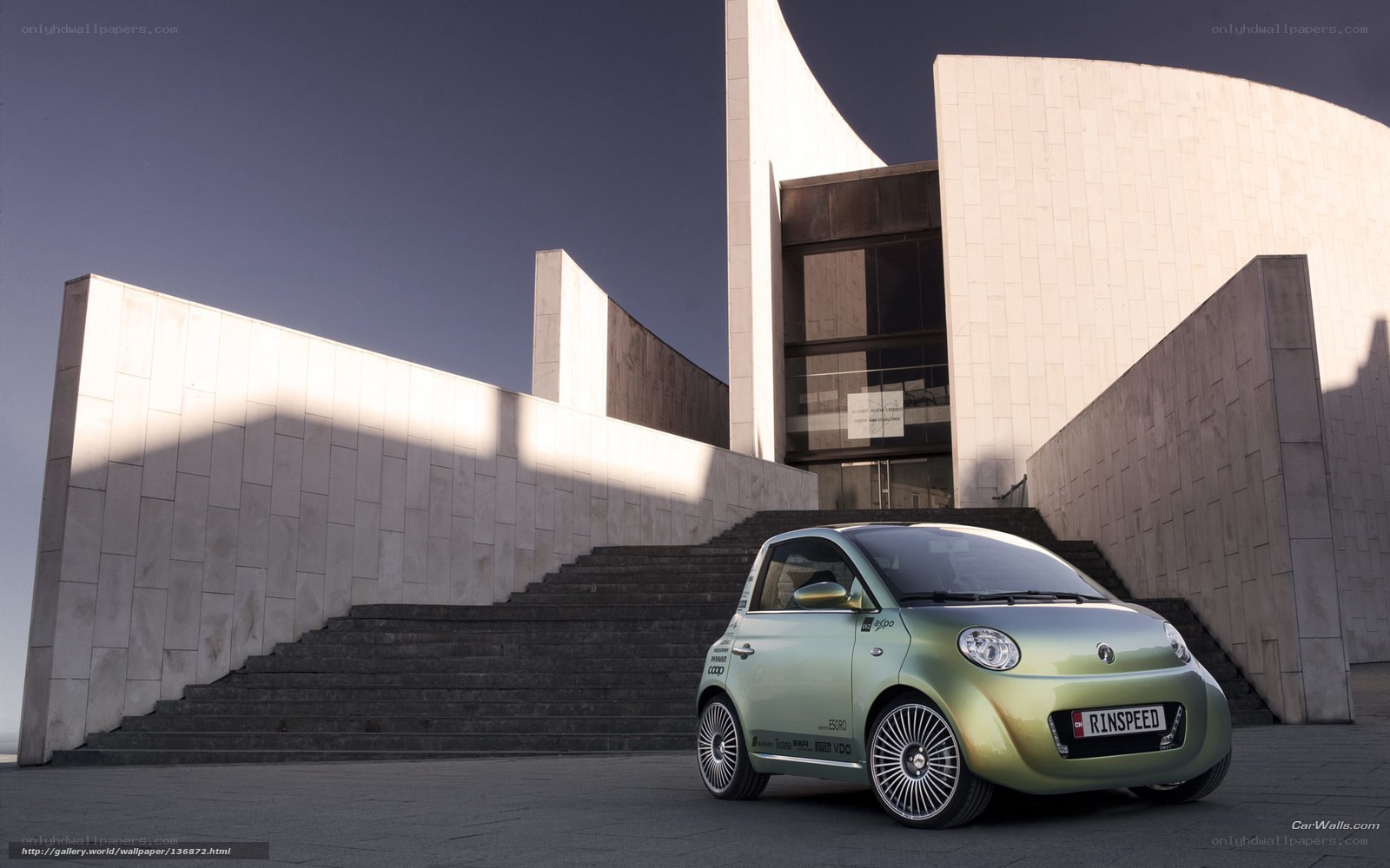 Green car in front of modern building