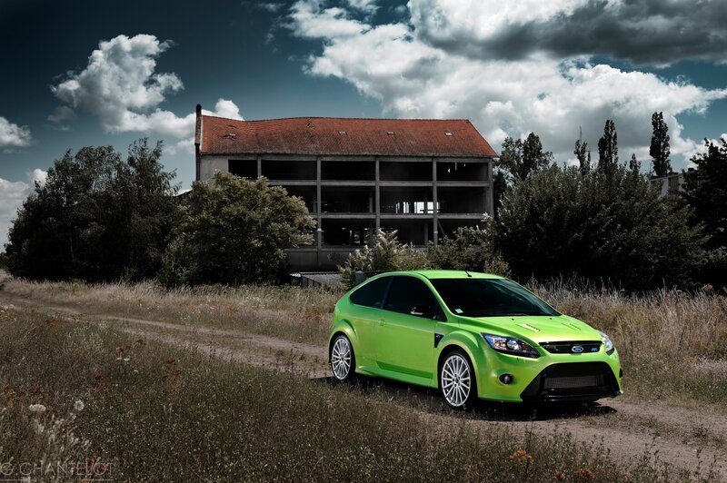 Green car in front of old building