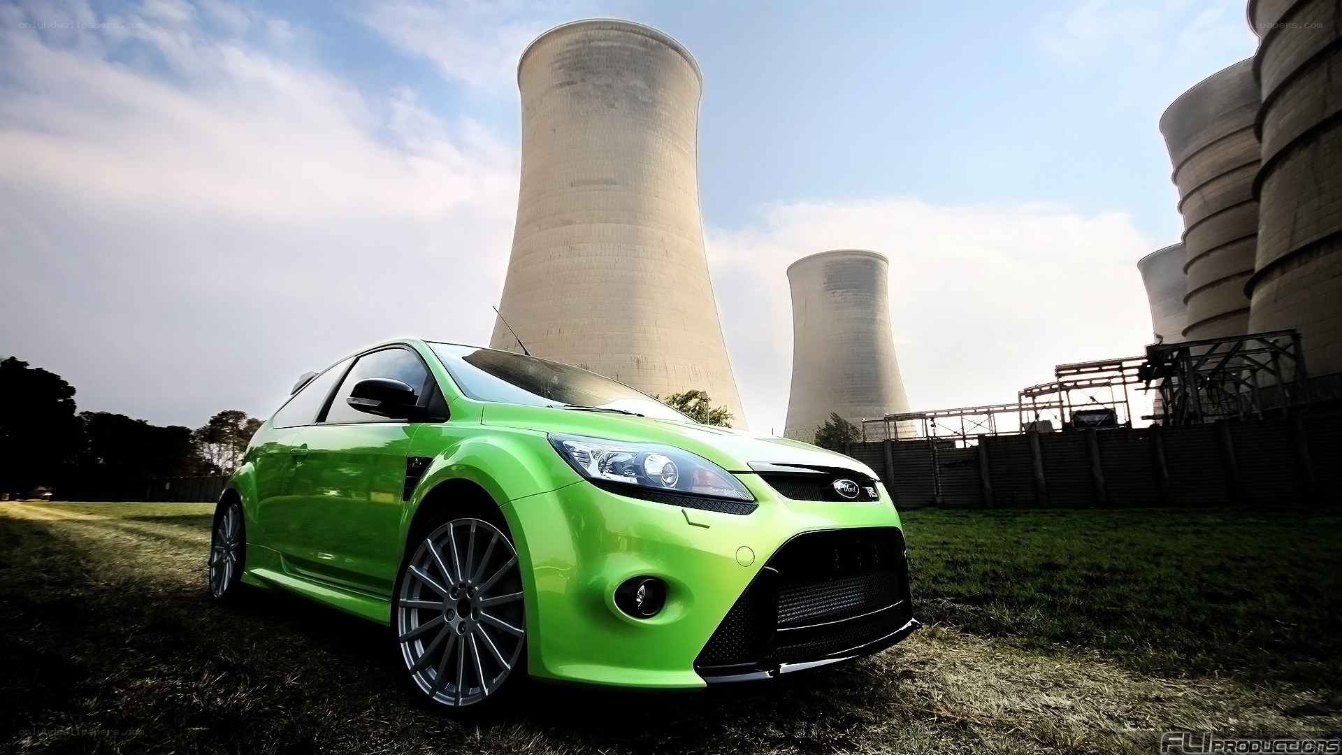 green car near cooling towers