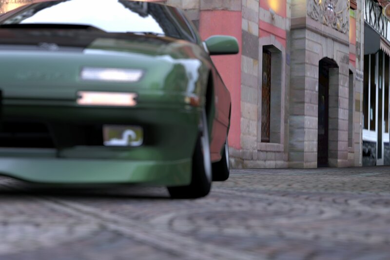 green car on cobblestone street