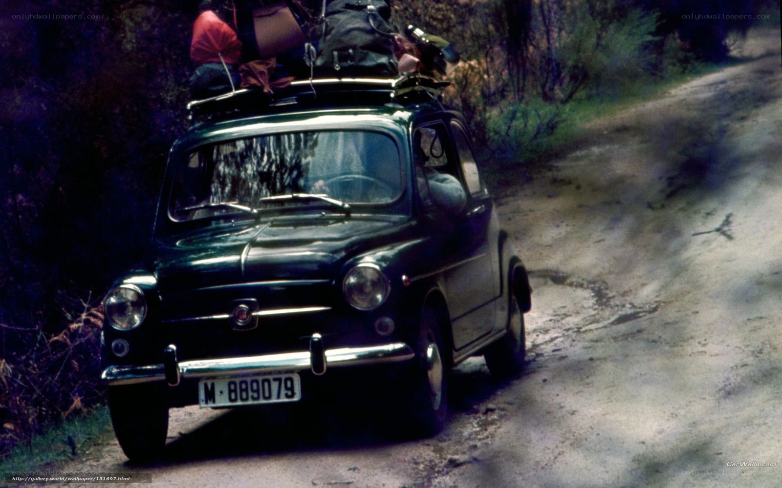 Green car on dirt road
