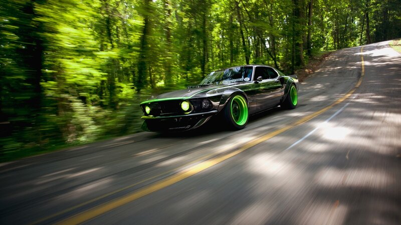 green car on forest road