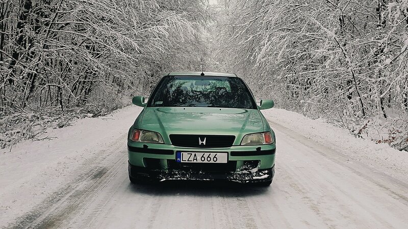 Green Car on Snowy Road