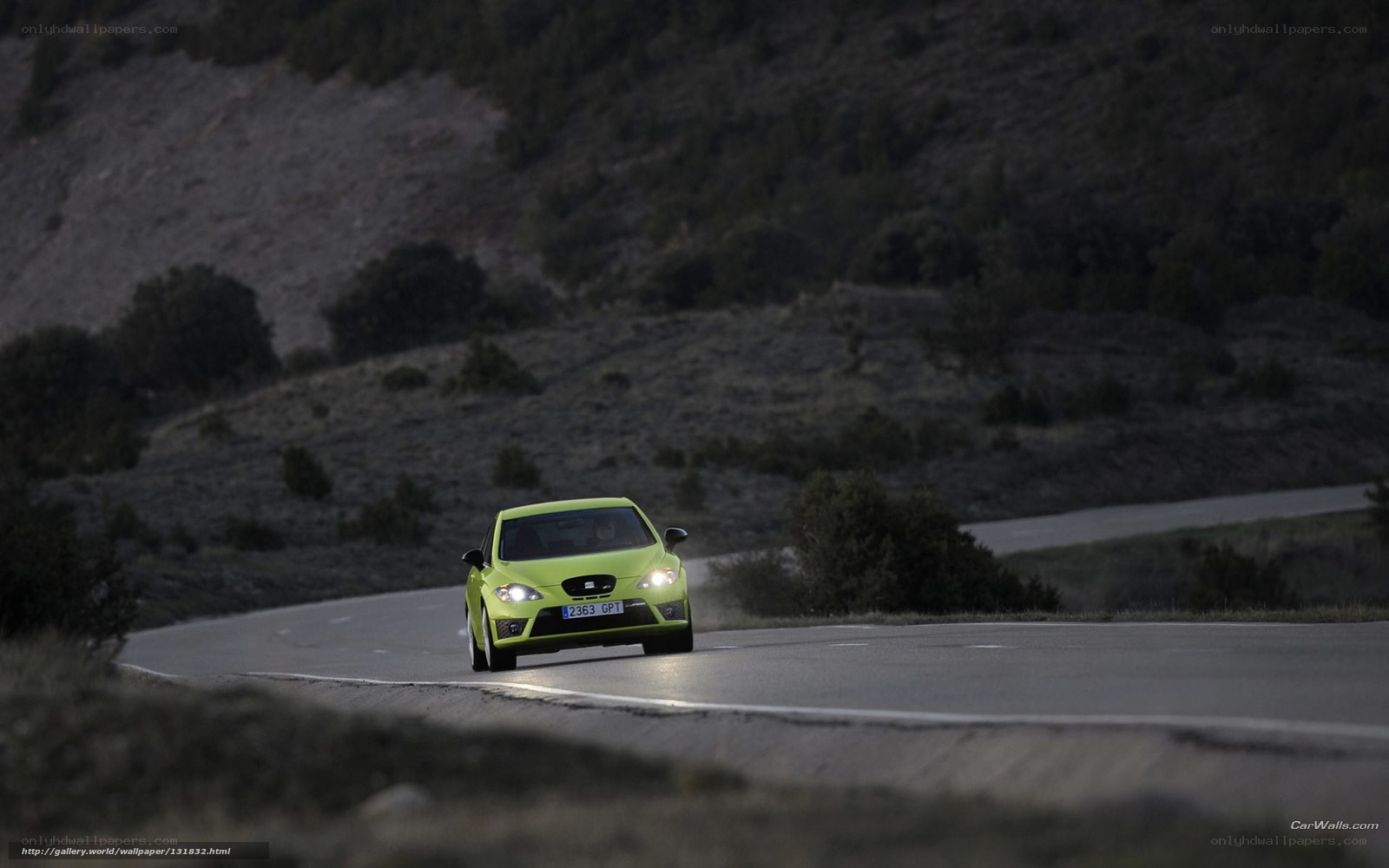 green car on winding road