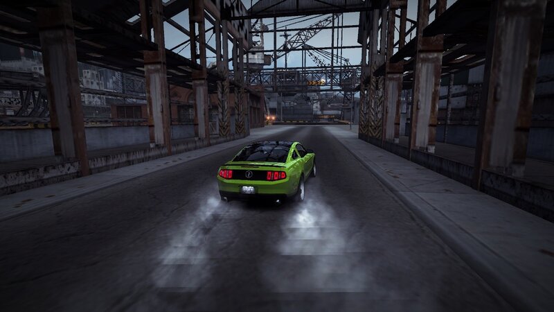 green car racing under bridge