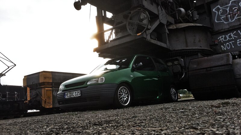 Green Car under Crane