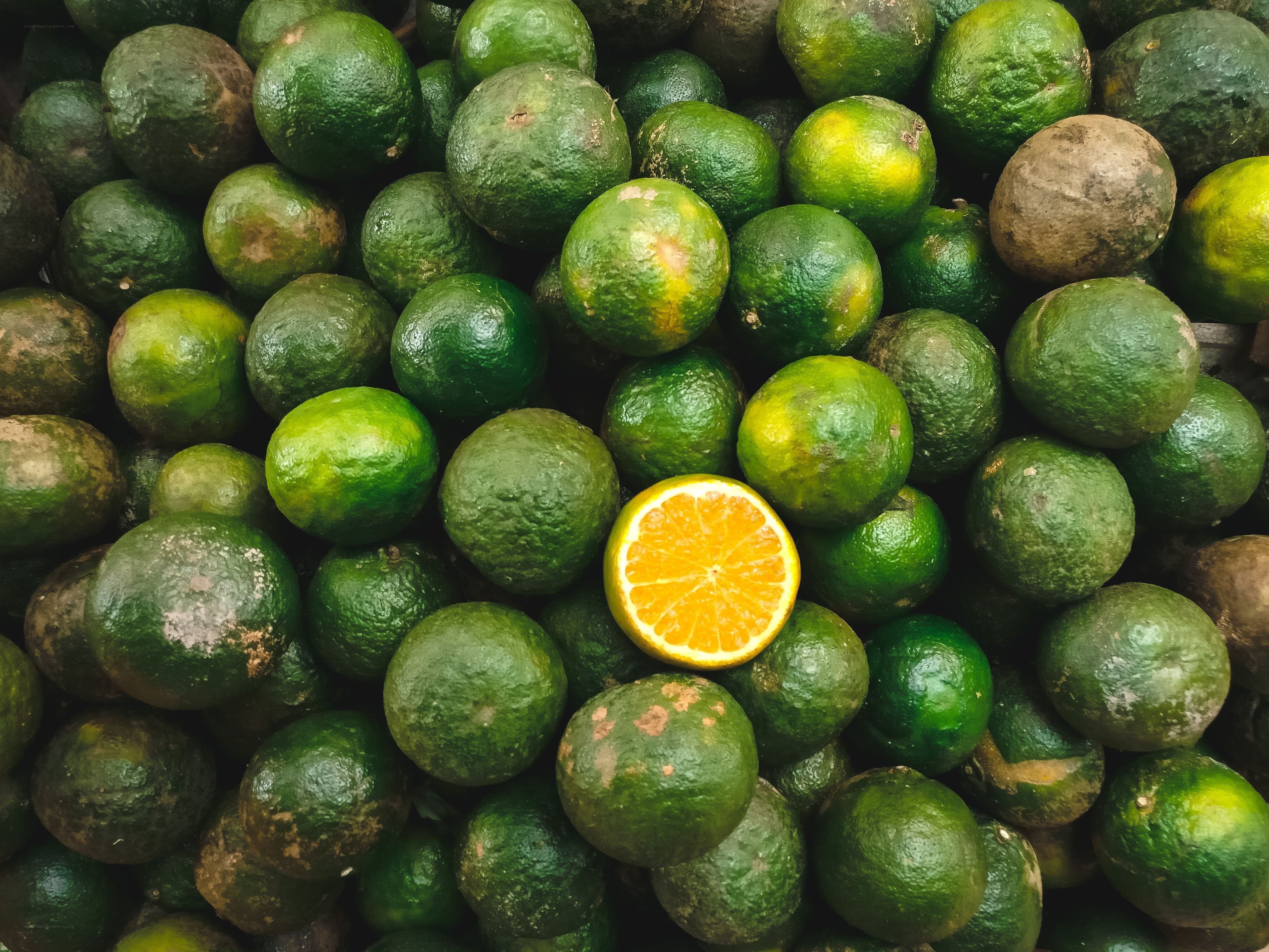 green citrus fruits with one orange slice