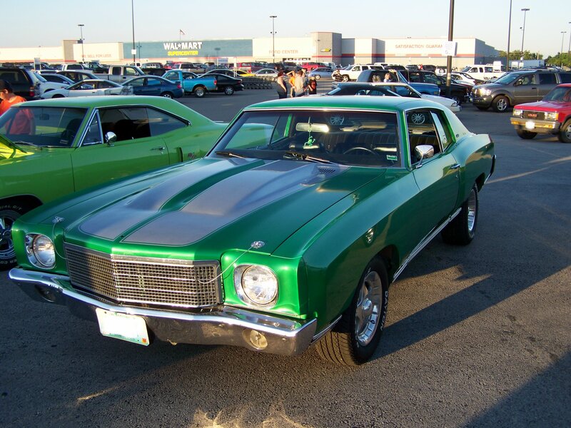 Green classic car at a parking lot