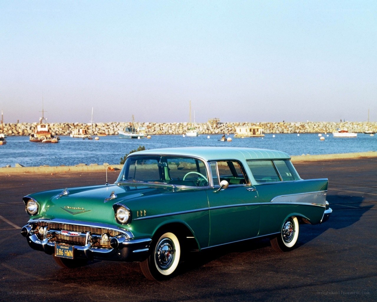 Green classic car by the harbor