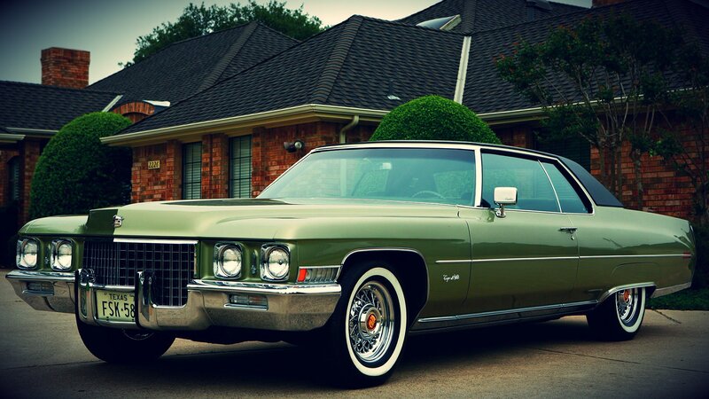green classic car in driveway