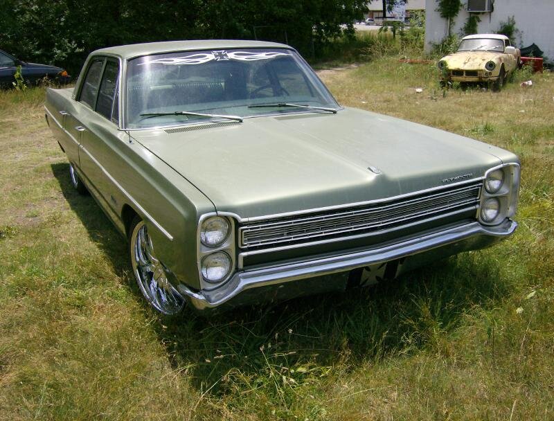 green classic car in grass