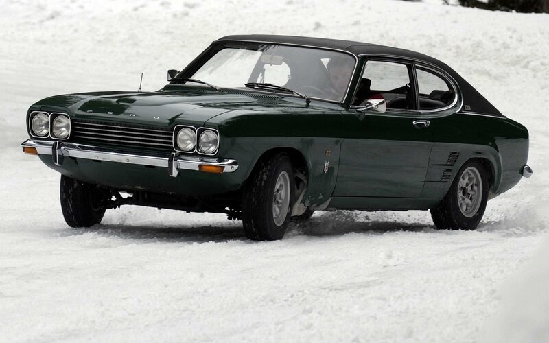 Green classic car in snow