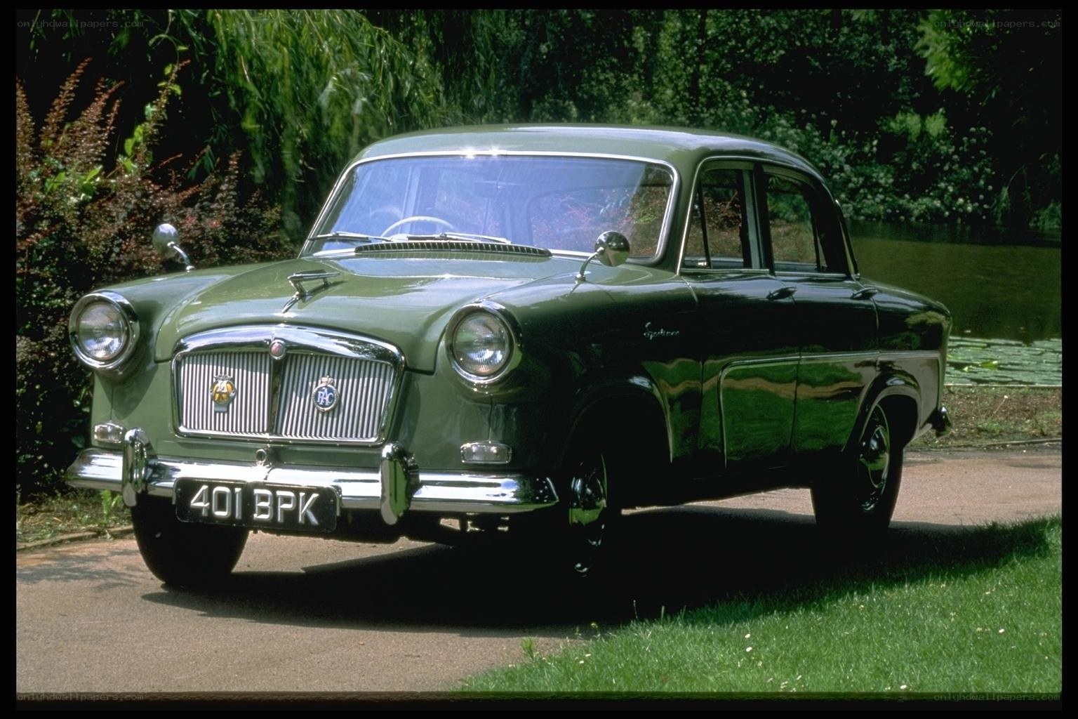 Green classic car on a driveway
