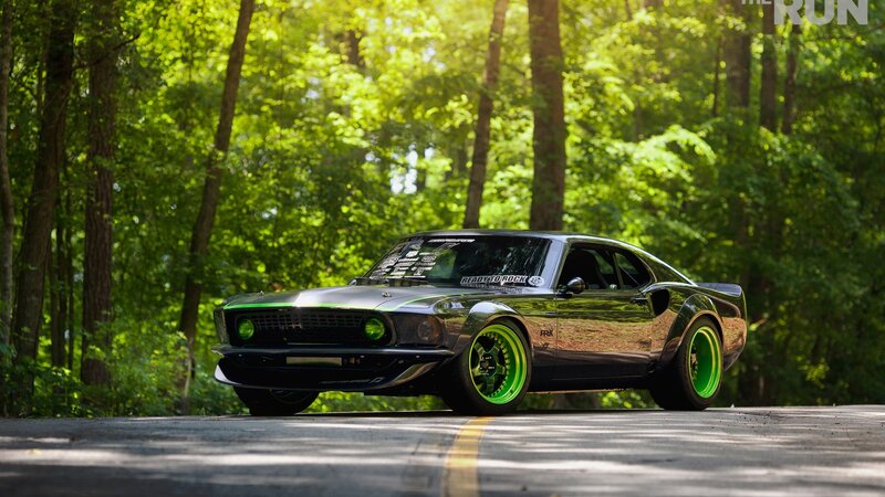 Green classic muscle car on forest road