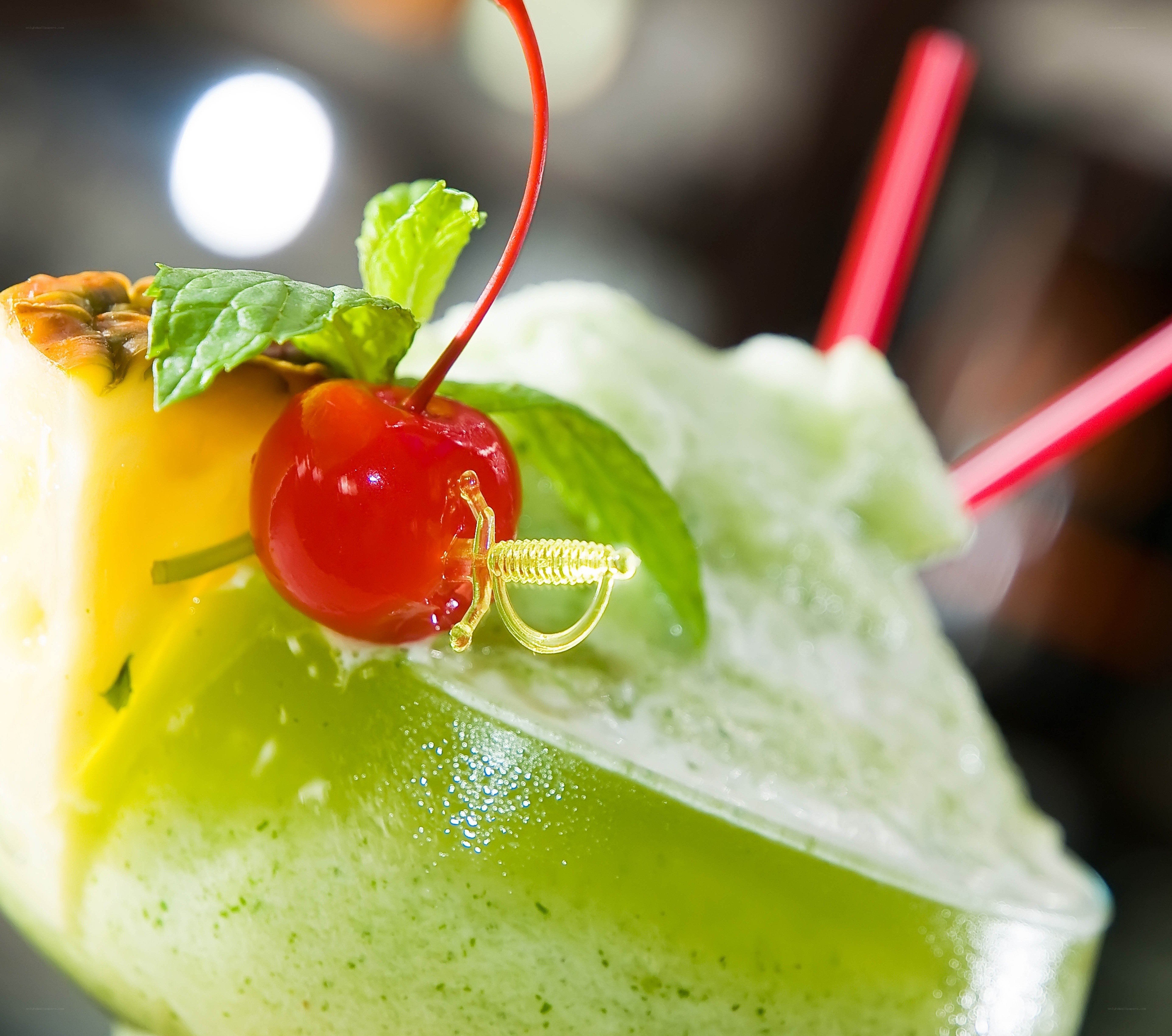 green cocktail with cherry and mint
