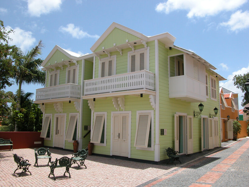 green colonial house with balconies