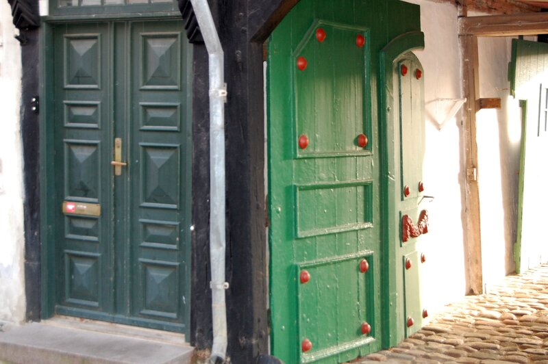 Green doors in a cobblestone alley