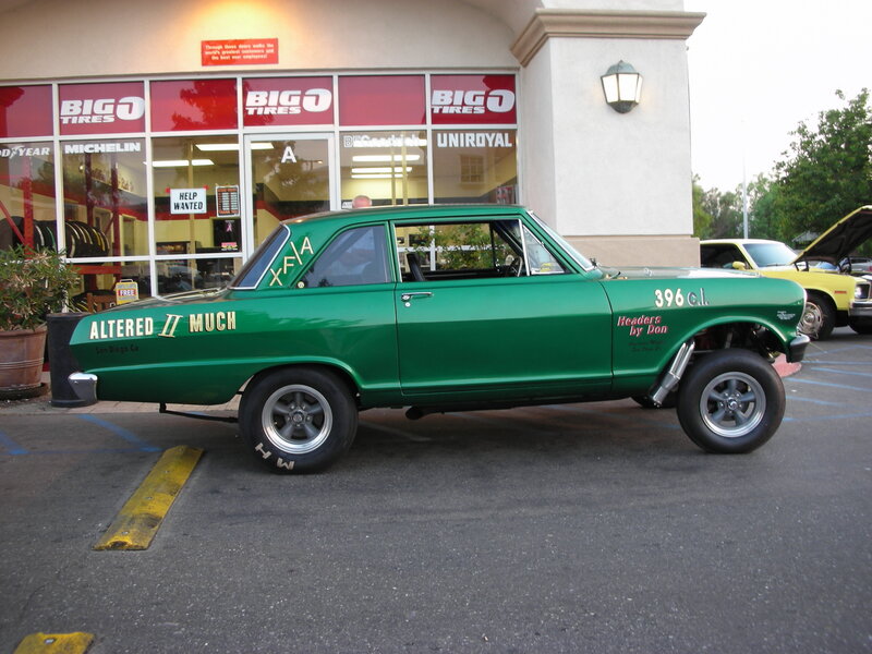 Green drag racing car outside tire shop