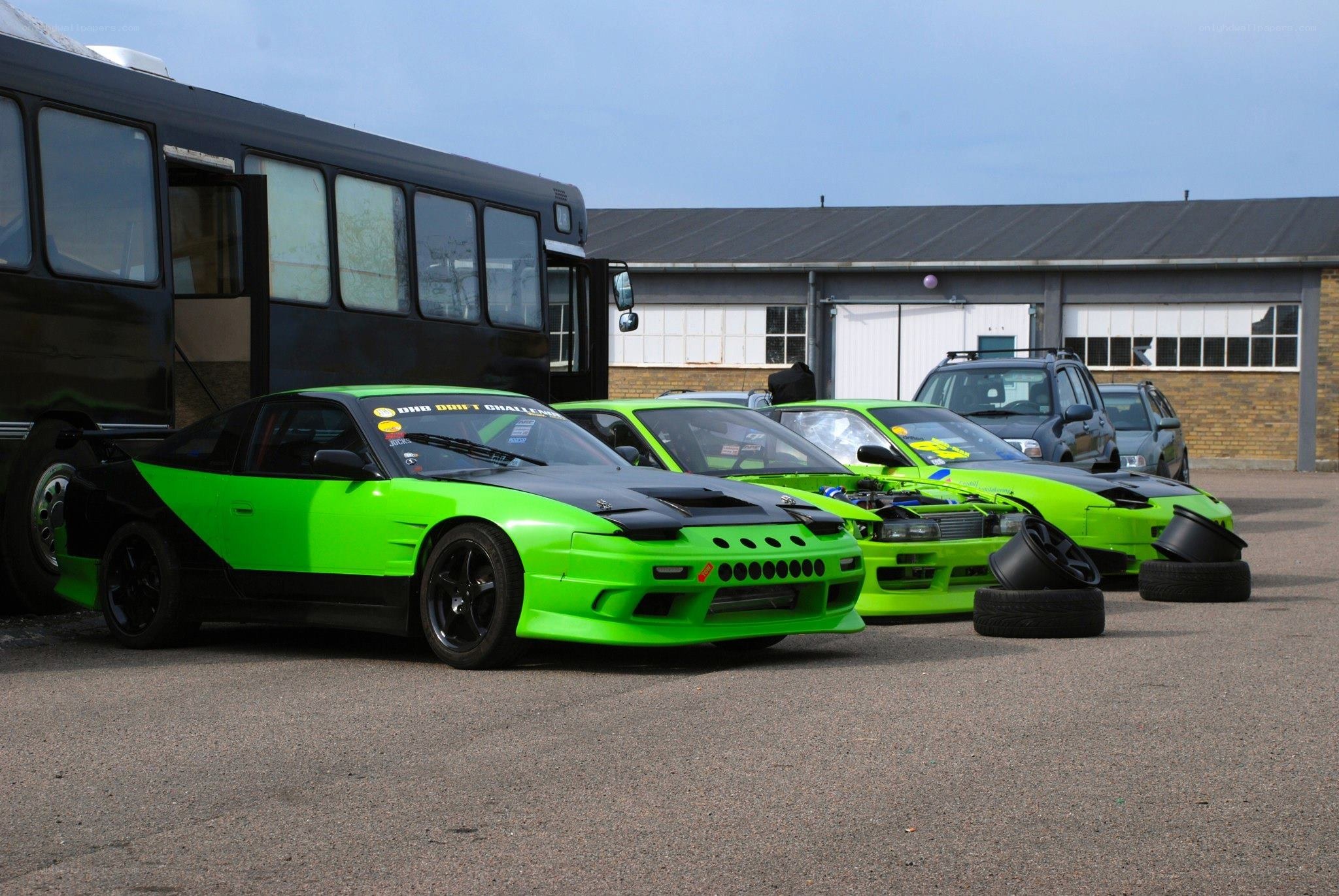 Green drift cars at a track
