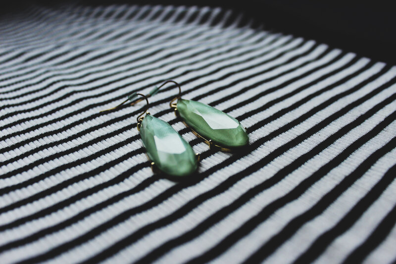 green earrings on striped fabric
