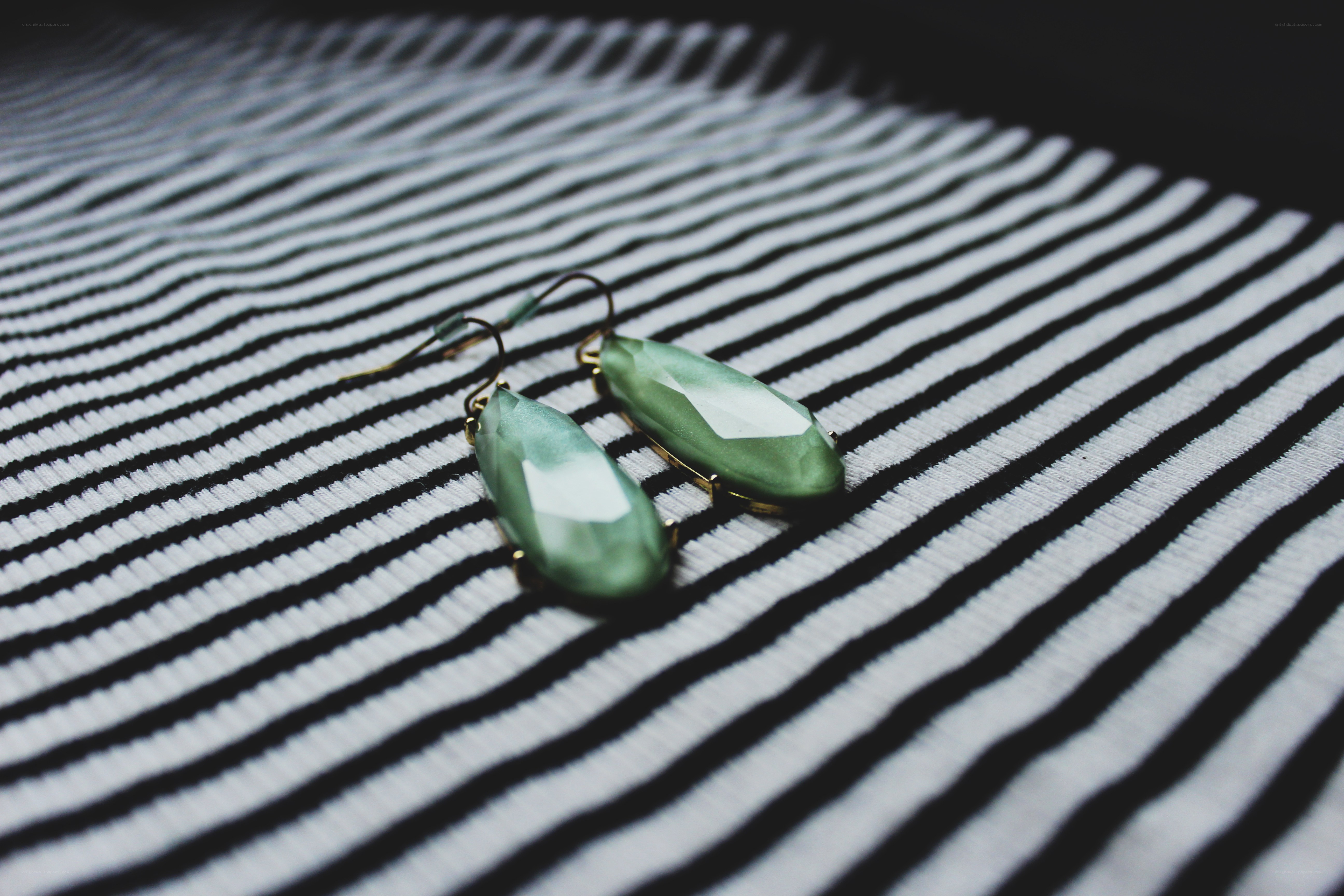 green earrings on striped fabric