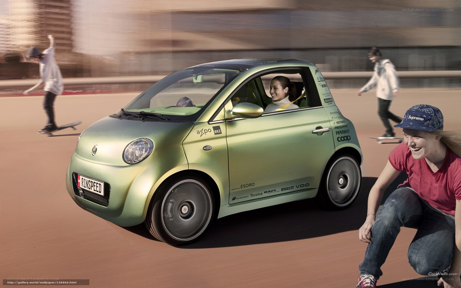 Green electric car with skateboarders