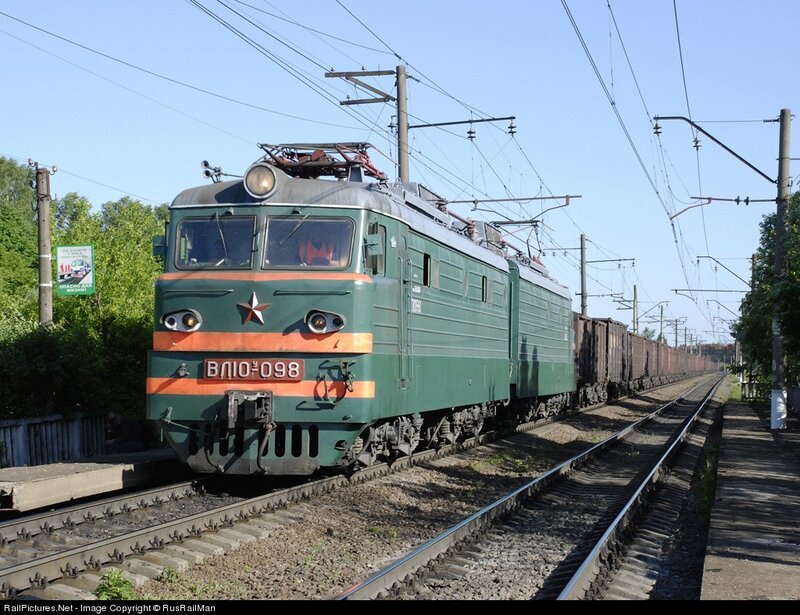 Green electric locomotive on tracks