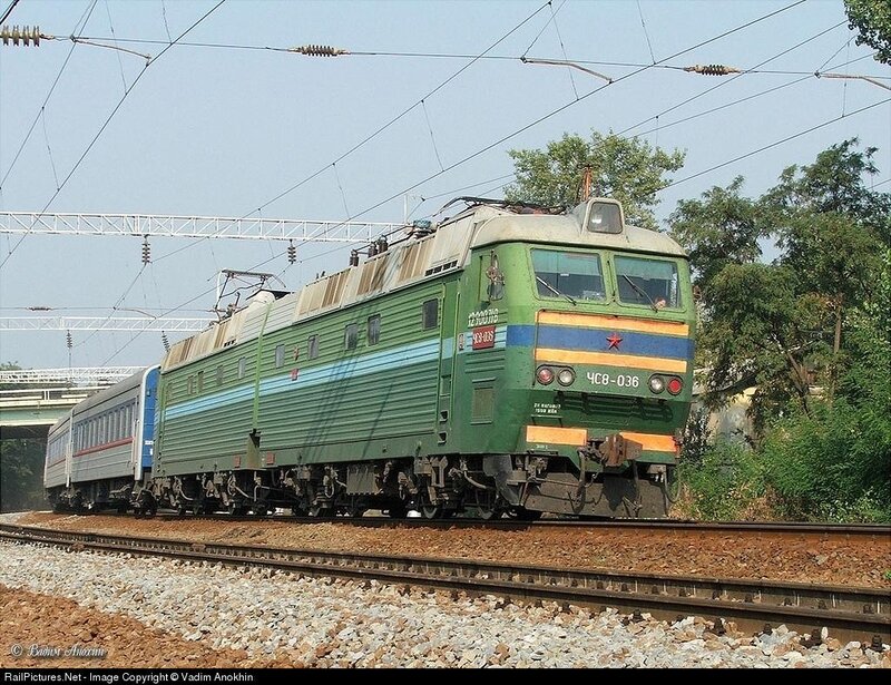 Green electric locomotive on tracks
